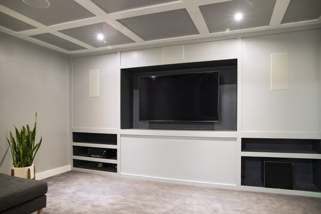 Basement media room speakers, television, coffered ceiling