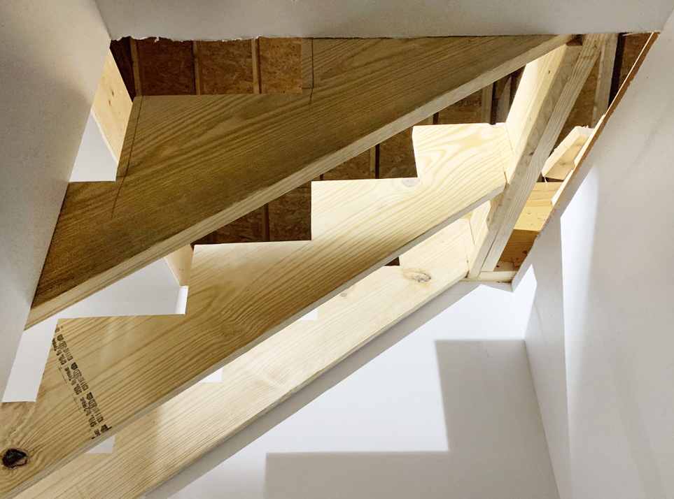 New stair stringers to room over garage from basement door view