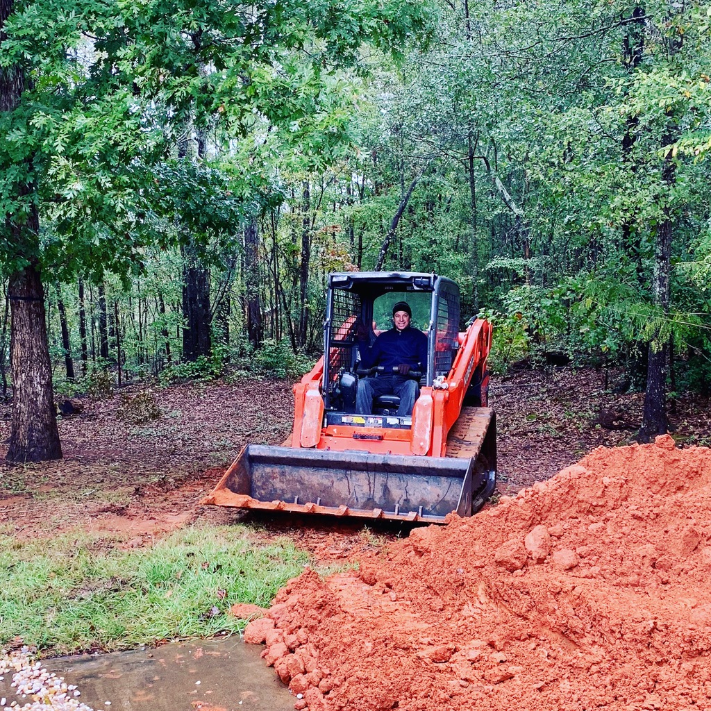 using a skid-steer to move dirt around the yard
