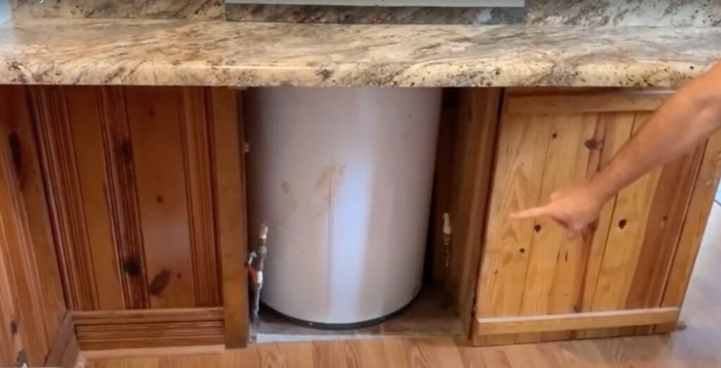 Old water heater in the middle of a kitchen. 