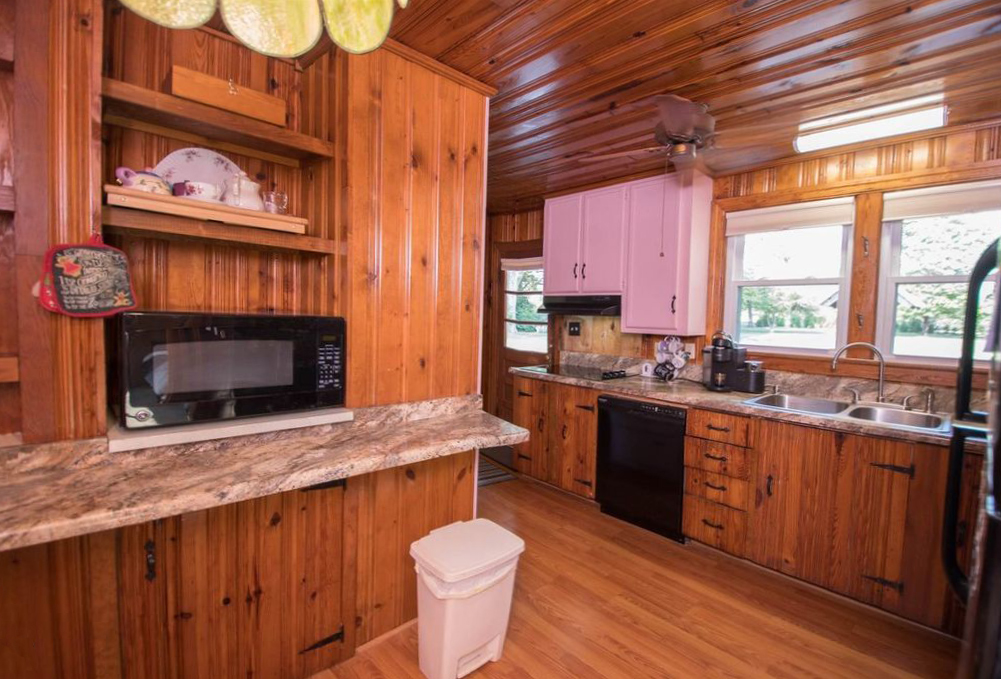Pink cabinet doors and lots of knotty pine on the walls and ceiling.
