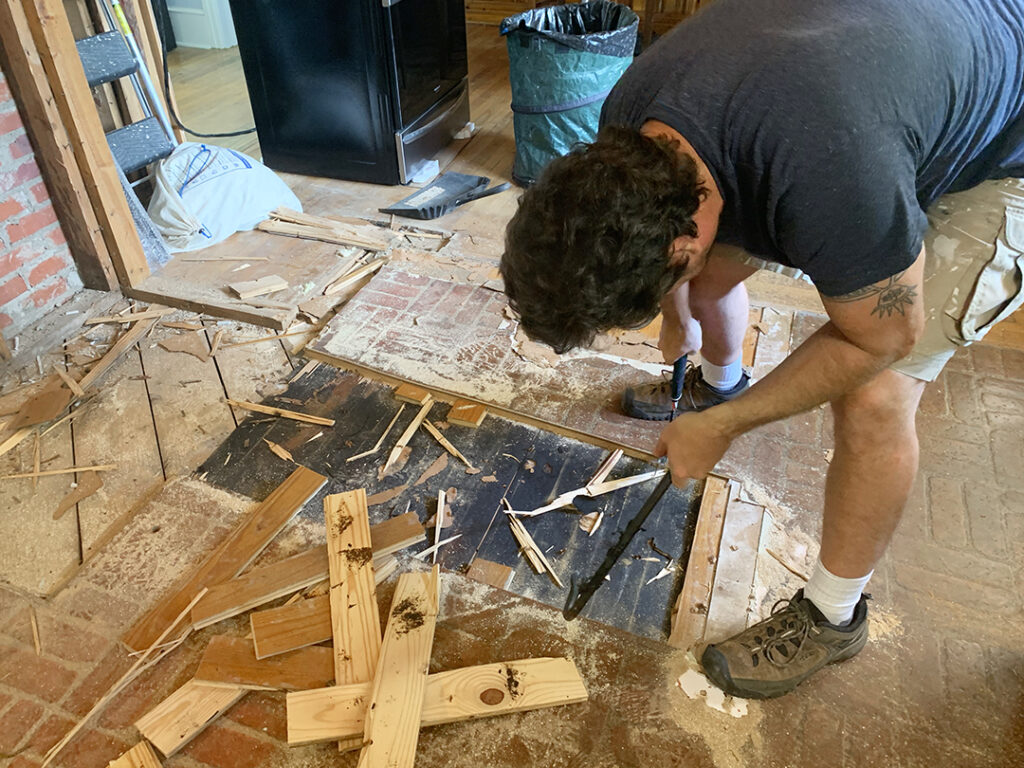 Chris tearing up the kitchen flooring layers down to the subfloor