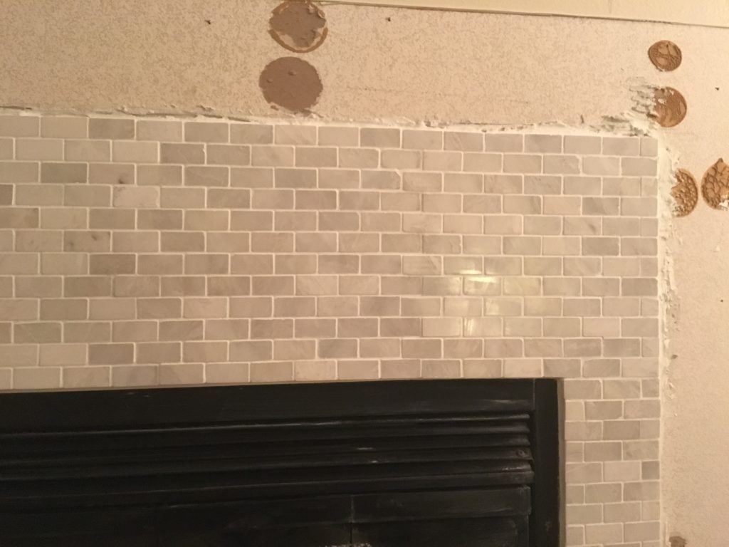 Closeup of the marble subway tile installed around the fireplace